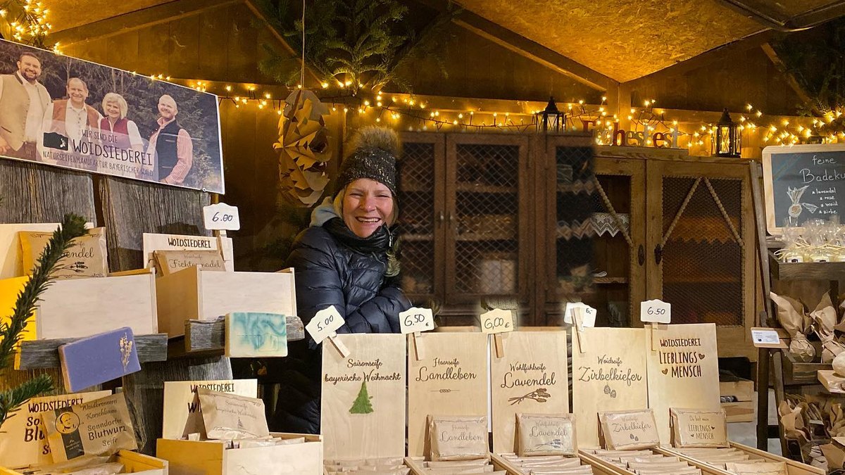 Marktstand der Woidsiederei auf dem Weihnachtsmarkt mit Lichterketten