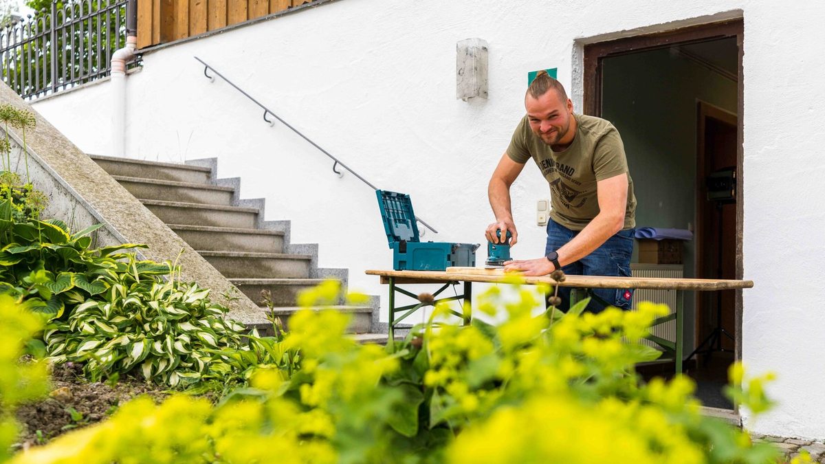 Johannes fertigt vor der Werkstatt Holzkisten